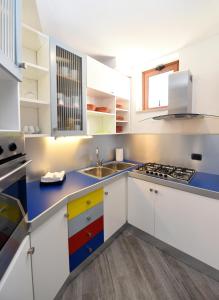 a kitchen with white cabinets and a sink at Appartamento Corso Italia 250 in Sorrento