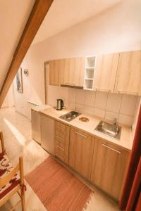 a kitchen with wooden cabinets and a sink at Apartments Hollaj in Ulcinj +41 photos