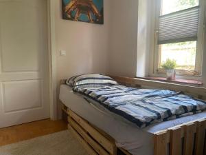 a bed sitting in a room next to a window at Old town Wall Radovljica - Appartment in Radovljica