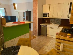 a kitchen with white cabinets and a green counter top at Old town Wall Radovljica - Appartment in Radovljica +13 photos