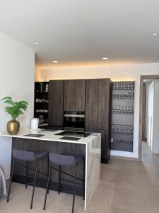 a kitchen with a island with bar stools at Cute little Penthouse in the Heart of Sliema in Sliema