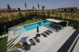 an overhead view of a swimming pool with chairs and avisor at Villa de luxe, petit déjeuner compris Golf in Marrakesh