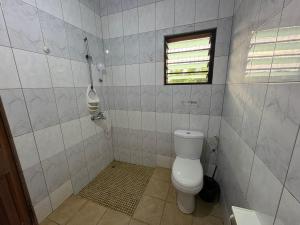 a bathroom with a toilet and a window at Sunflower Beach Resort in Senya Beraku