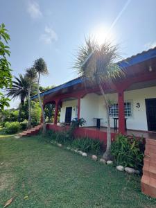 a house with a palm tree in front of it at Sunflower Beach Resort in Senya Beraku