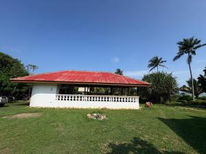 a small white building with a red roof at Sunflower Beach Resort in Senya Beraku +8 photos