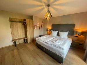 a bedroom with a bed with white sheets and pillows at Bergflamme - Ihr Ferienhaus im Harz mit Panoramasauna in Braunlage