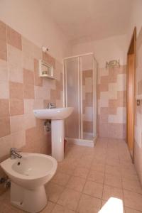a bathroom with a toilet and a sink and a shower at Fondaco del Capo in Capo Vaticano