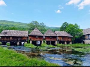 a group of wooden buildings next to a river at The Nest Otočac in Otočac