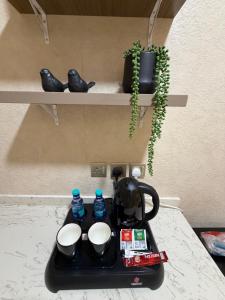 a tea pot and cups on a tray on a table at لينك هوم استديو فندقي دخول ذاتي in Buraydah +1 photo