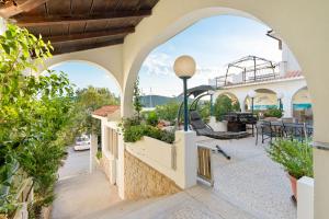 an external view of a house with arches at Black Pearl Tisno in Tisno