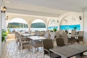 a restaurant with tables and chairs and the water at Black Pearl Tisno in Tisno