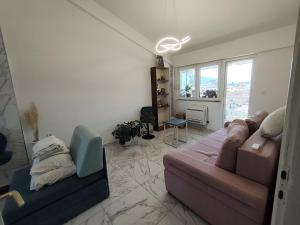 a living room with a couch and a window at Golden Age Rooftop Apartment in Ohrid