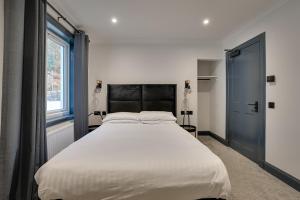 a bedroom with a large white bed and a window at The Righ in Oban