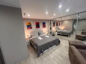 a bedroom with a bed and a living room at Apartmány Centrum Trenčín - Greenyard in Trenčín