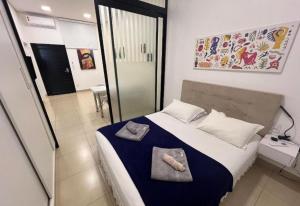 a bedroom with a bed with two towels on it at Smart Studio Cataratas Luxo in Foz do Iguaçu