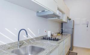 a kitchen with a sink and a refrigerator at Smart Studio Cataratas Luxo in Foz do Iguaçu +6 photos