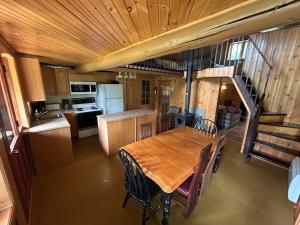 a kitchen and dining room with a wooden table and chairs at Chalet de toutes saisons in Shawinigan