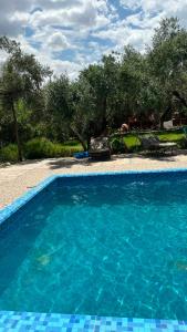 a large blue swimming pool next to a yard at Tissi House in Tahannout