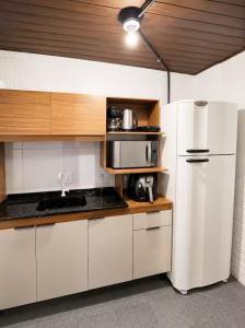 a kitchen with white appliances and a white refrigerator at Nônames Urban Hostel in Florianópolis