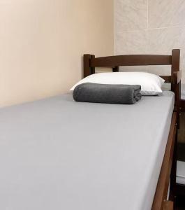 a bed with a pillow on top of it at Nônames Urban Hostel in Florianópolis