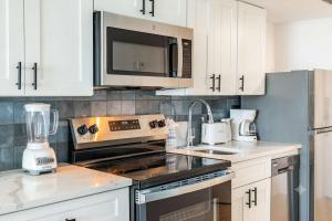 a kitchen with a stove and a microwave at Coastal Modern Oceanfront 2BR Yachtsman S506 in Myrtle Beach