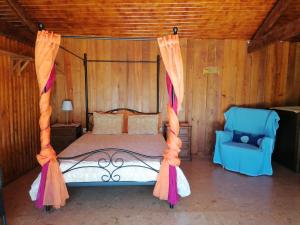 a bedroom with a canopy bed and a chair at Country House - Hippie Garden in Vieira do Minho