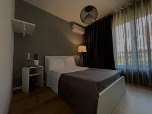 a bedroom with a bed and a large window at Patushe Guesthouse in Shkodër