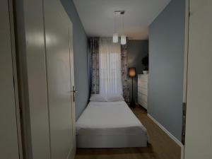 a small bedroom with a white bed and a closet at Patushe Guesthouse in Shkodër +13 photos