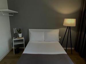 a bedroom with a white bed and a lamp at Patushe Guesthouse in Shkodër