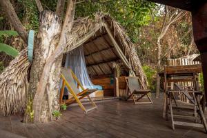a cabin with a hammock and a tree at El Bosque Minca in Minca