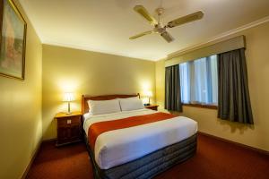 a hotel room with a bed and a ceiling fan at Gateway on Monash in Clayton North