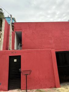 a red building with a door and a basketball hoop at Lindo Apto Mobiliado, Smart TV - Caieras in Caieiras