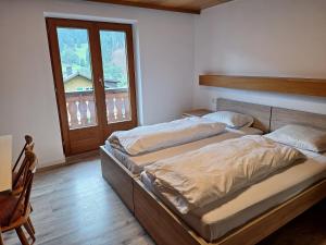 two twin beds in a room with a window at Montafon Valley Rooms in Sankt Gallenkirch +8 photos