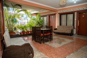 a living room with a table and chairs and plants at Admire Hotel Pvt Ltd in Pokhara