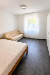a room with a bed and a couch and a window at Four Rooms Allgäu Apartment in Wangen im Allgäu