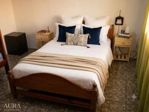 a bedroom with a large bed with blue pillows at Calma chicha casa 1 in Cortaderas