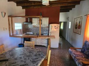 a room with a kitchen and a table and a refrigerator at Calma chicha casa 1 in Cortaderas