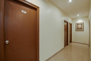 a corridor with a brown door and a hallway at Hotel O Anu Grand in Visakhapatnam