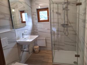 a bathroom with a shower and a sink at Montafon Valley Rooms in Sankt Gallenkirch