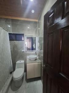 a bathroom with a toilet and a sink at Paradise 1 in Jacó +12 photos