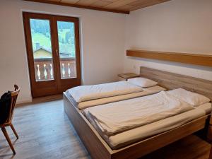 a bedroom with a bed and a large window at Montafon Valley Rooms in Sankt Gallenkirch