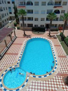 a large swimming pool in front of a building at Arenabeach in Martil