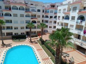 an overhead view of a building with a swimming pool and palm trees at Arenabeach in Martil