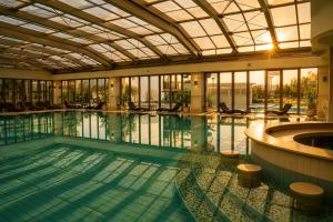 a large swimming pool with a glass ceiling at Boutique 1BR | Long Beach Sea View Next to the Beach in Shkorpilovtsi