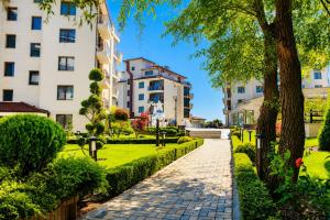 a walkway in a park with buildings at Boutique 1BR | Long Beach Sea View Next to the Beach in Shkorpilovtsi