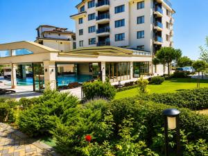 a building with a swimming pool in front of a building at Boutique 1BR | Long Beach Sea View Next to the Beach in Shkorpilovtsi