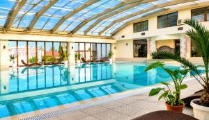 an indoor swimming pool with a glass ceiling at Boutique 1BR | Long Beach Sea View Next to the Beach in Shkorpilovtsi +18 photos
