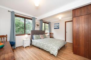 a bedroom with a bed and some windows at Relax Moore - Close to Beach in Guilderton