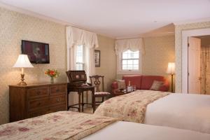 a hotel room with two beds and a desk with a chair at Deerfield Inn in Deerfield