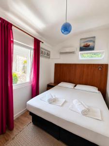 a bedroom with a bed with red curtains and a window at Apartments Hollaj in Ulcinj